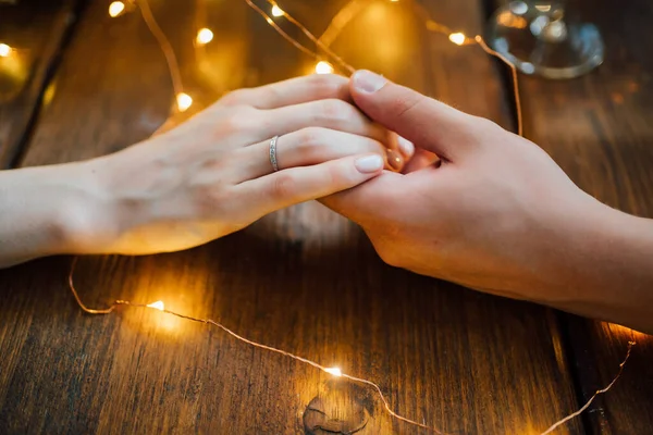 Arms. loving couple sitting at table and holding hands. — Stock Photo, Image