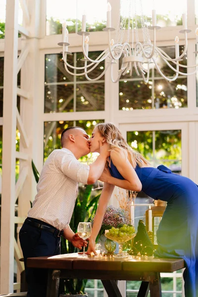 Cena romantica. ragazza con bicchiere di vino sta sul tavolo per baciare il fidanzato. — Foto Stock