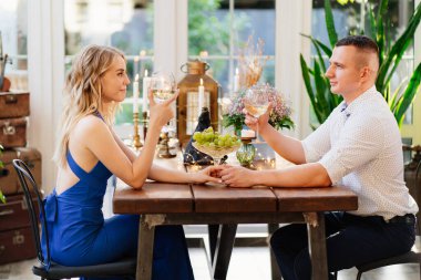 Çiftler için romantik bir yemek. Aşıklar kadehten şarap içer.