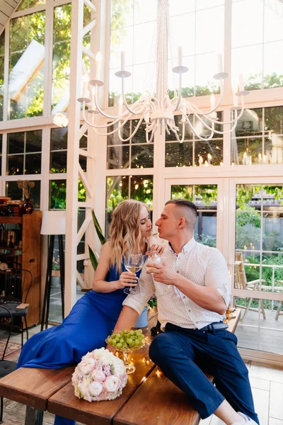 Pareja bebiendo vino sentado en la mesa. luna de miel . — Foto de Stock