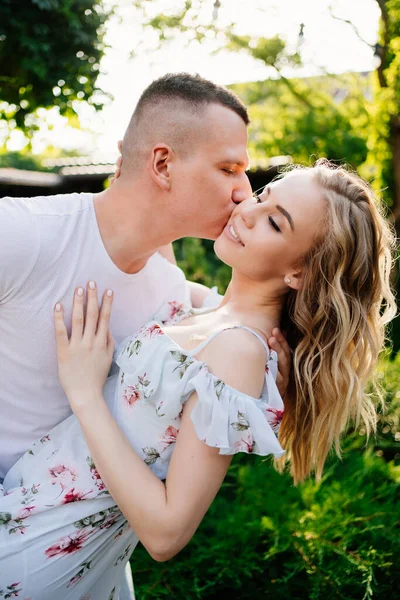 Hermosa y feliz pareja divirtiéndose en el jardín . — Foto de Stock