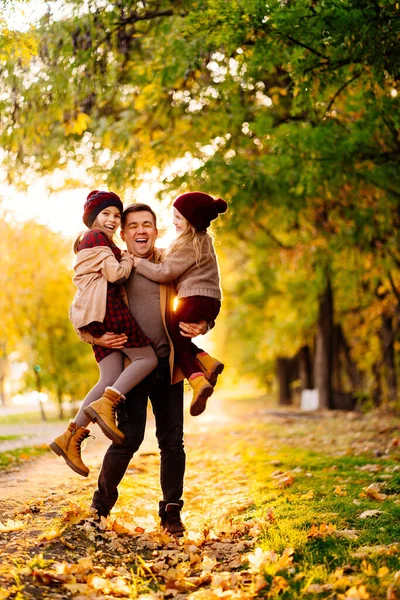 Pôr-do-sol. pai com filhas andando e se divertindo no outono Park. família feliz . — Fotografia de Stock