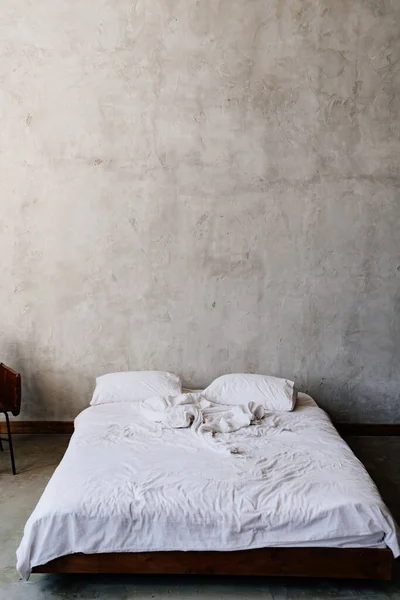 Loft. cama cerca de la pared gris — Foto de Stock