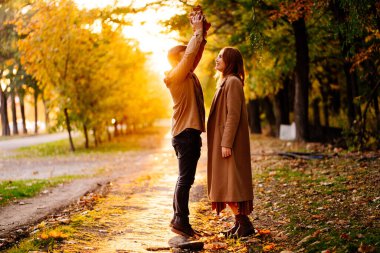 Gün batımı. Autumn Park 'ta yürüyen bir çift. Aile hayatı