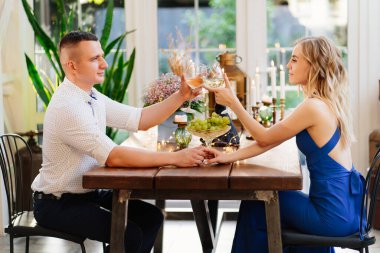 Çiftler için romantik bir yemek. Aşıklar kadehten şarap içer.