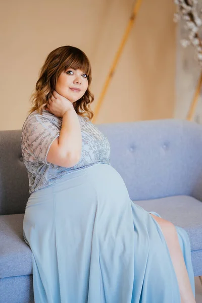 妊娠中の服を着たままソファに座って — ストック写真