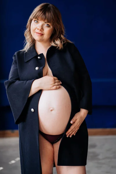 En topless, hermosa embarazada con sobrepeso en una chaqueta azul . — Foto de Stock