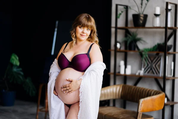 속옷과 흰색 외투를 입고 배를 젓고 있는 임신부. — 스톡 사진