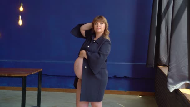 Zwanger met extra gewicht van gelegenheid. fotograaf past haar op model. — Stockvideo