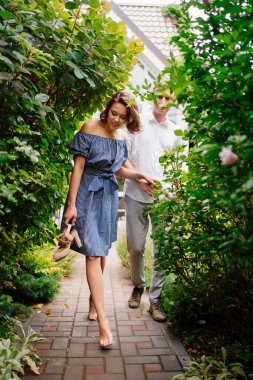 Kadın erkeği tutar ve bahçeye götürür.. 