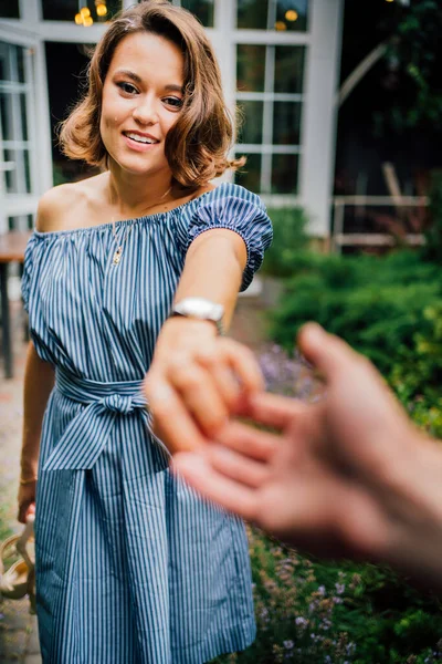 Kvinna håller hand man och leder till trädgården. — Stockfoto