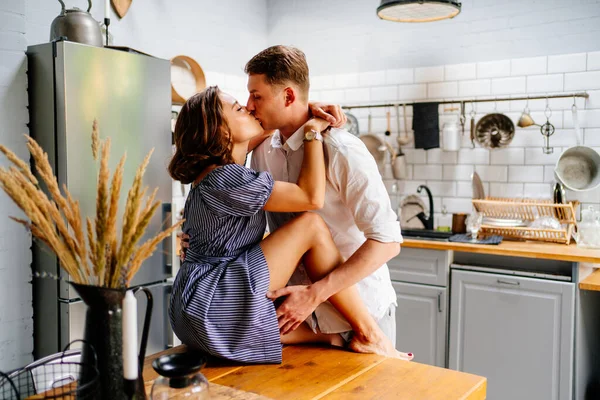 Pár objímající se doma v kuchyni. novomanželé na líbánkách. — Stock fotografie