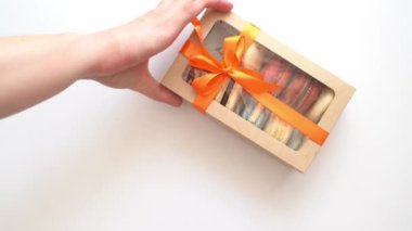 Kurdeleli ve içinde makarna olan kutu beyaz masada kareye girer. birkaç kez.