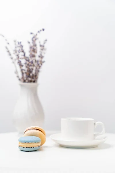 Macarons on background Cup and vase with lavender. — Stock Photo, Image