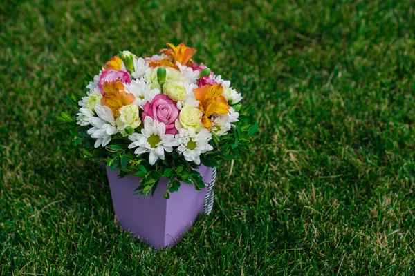 Букет красочных цветов в шляпной коробке на газоне. место для текста. — стоковое фото