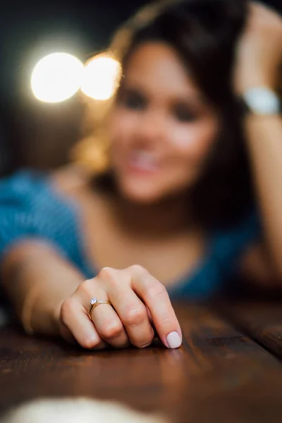 Жіноча рука з обручкою на пальці на дерев'яному столі . — стокове фото