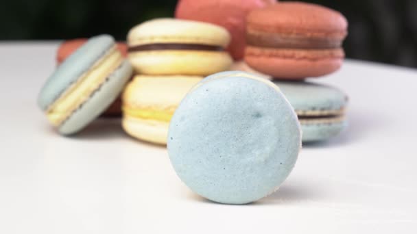 Macarons de ingredientes naturais, macaron azul rolando em uma mesa branca . — Vídeo de Stock