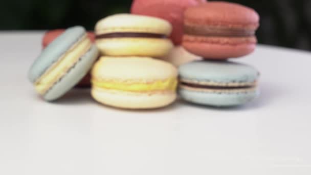 Varias veces en fila macaron azul rodando sobre una mesa blanca. — Vídeos de Stock