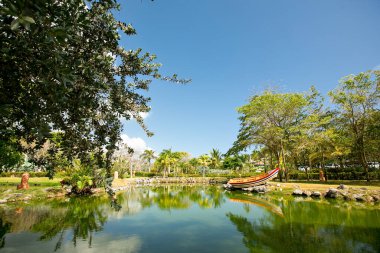 Tropikal bahçelerle çevrili tekneli gölet.