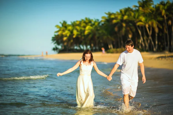 Coppia in abiti bianchi in acqua sulla spiaggia. — Foto Stock