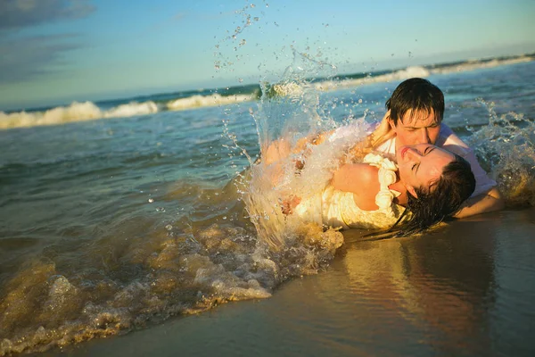 Amantes molhados mentir na praia na água e beijo . — Fotografia de Stock