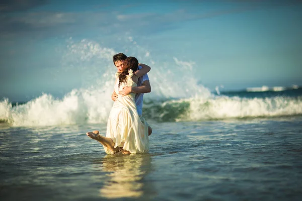 Пара в белой одежде в воде на пляже. — стоковое фото