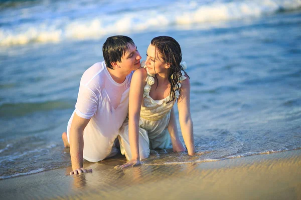 Νιόπαντροι με βρεγμένα ρούχα φλερτάρουν στην παραλία. — Φωτογραφία Αρχείου