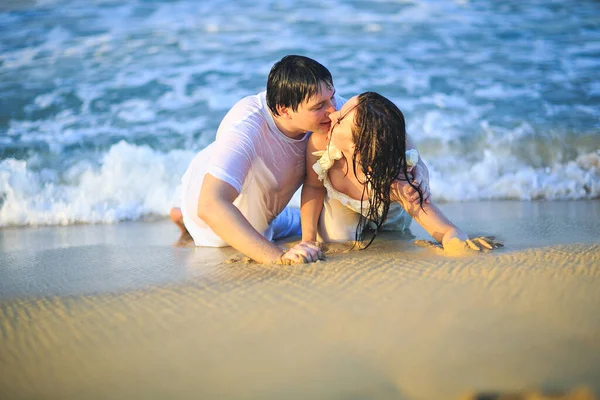 Recém-casados em roupas molhadas flertando deitado na praia . — Fotografia de Stock