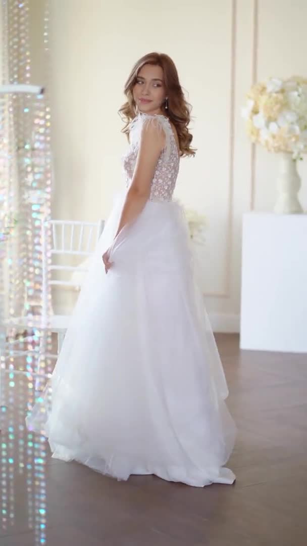 Gyönyörű menyasszony pózol az ablakban — Stock videók