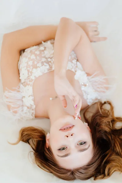 Vista superior. novia en vestido blanco acostado en la cama. — Foto de Stock