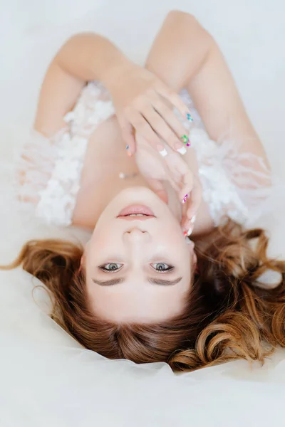 Vista superior. noiva em vestido branco deitado na cama . — Fotografia de Stock