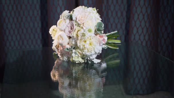 Ramo de flores delicadas acostado en el espejo oscuro de la mesa y se refleja. — Vídeos de Stock