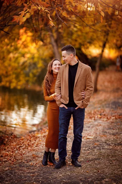 가을 공원에서 남편과 함께 강을 타고 임신 한 모습. — 스톡 사진