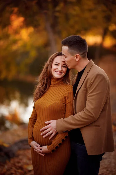 Güz Parkı 'nda nehrin kenarında kocasına hamile.. — Stok fotoğraf