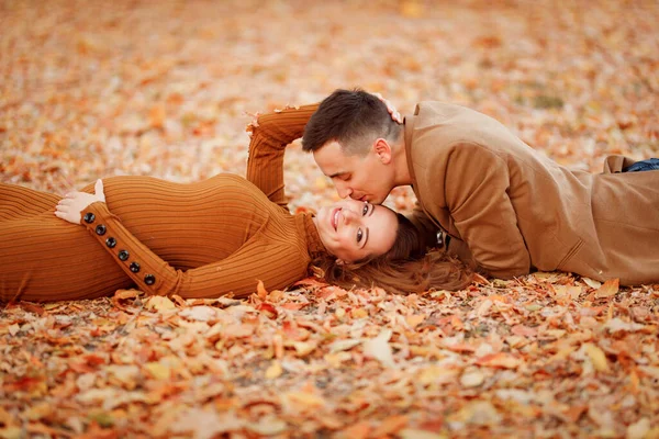 Mulher grávida com marido encontra-se no outono Parque — Fotografia de Stock