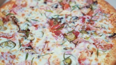 Yakın plan. Peynirli, domatesli, salatalıklı ve sosisli büyük pizza.