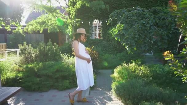Al tramonto di coppia felice, in attesa di bambino, in giardino in cortile. — Video Stock
