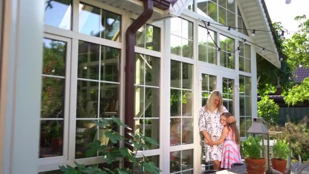 Dcera hladí bříško těhotné matky stojící v zahradě na dvorku. — Stock video