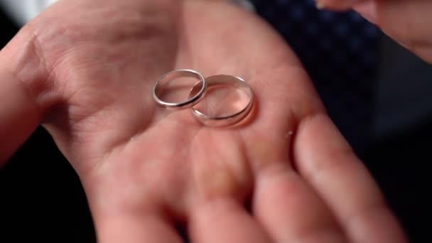 Primer plano. tres anillos de boda en la mano de un hombre. — Vídeos de Stock