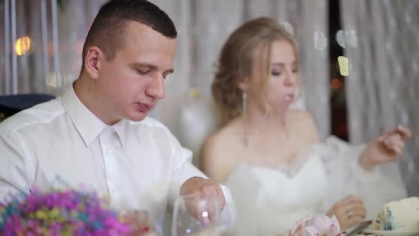 Brud och brudgum äter på gala bankett på bröllopet. — Stockvideo