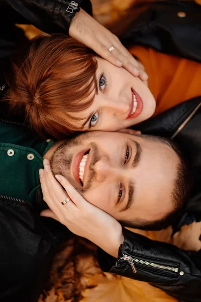 Close up. man and woman lying on autumn leaves — Stock Photo, Image