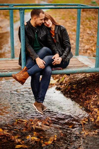 Homem e mulher na ponte sobre o fluxo no outono Park — Fotografia de Stock