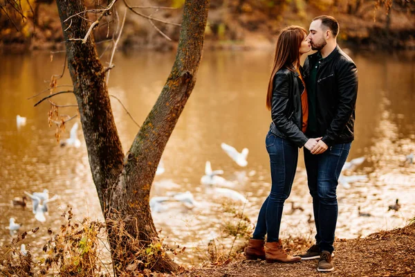 Mężczyzna i kobieta flirtować w jesiennym parku w pobliżu rzeki. — Zdjęcie stockowe