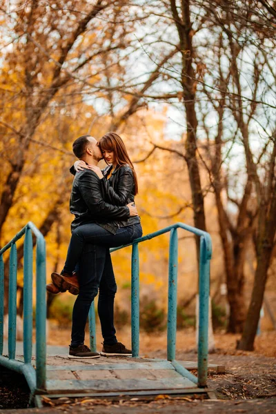 Homem e mulher na ponte sobre o fluxo no outono Park — Fotografia de Stock