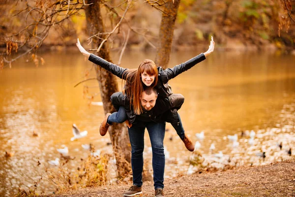 Homme et femme flirter dans le parc d'automne près de la rivière. — Photo