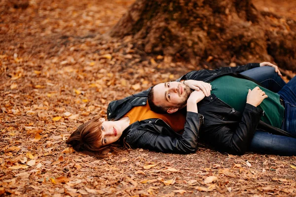 Casal está deitado no parque de outono . — Fotografia de Stock