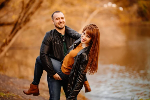 Mann und Frau flirten im Herbstpark in Flussnähe. — Stockfoto