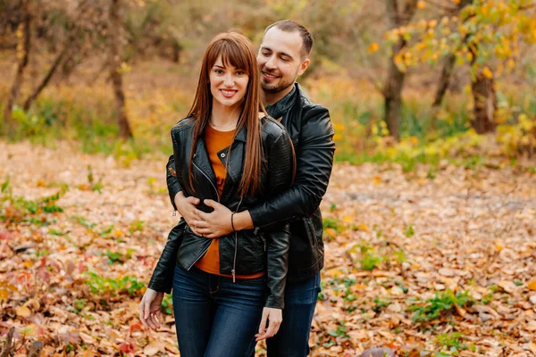 Мужчина и женщина обнимаются и флиртуют в осеннем парке. — стоковое фото