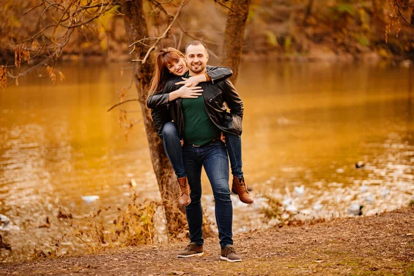 Mann und Frau flirten im Herbstpark in Flussnähe. — Stockfoto