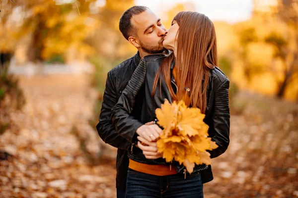Man en vrouw met een van gele esdoorn bladeren — Stockfoto